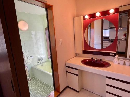 a bathroom with a sink and a mirror and a tub at Pets OK! Close to the sea! Starlit House with a dog run AC8 in Hasunuma