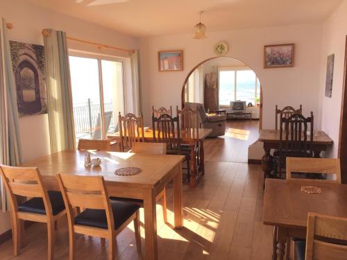 een eetkamer met tafels en stoelen en een woonkamer bij O'Neill's Bed&Breakfast in Ballyheigue