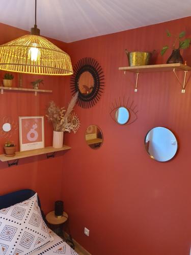 a bedroom with red walls with mirrors and a lamp at studio cosy idéalement situé parking privé in Ajaccio