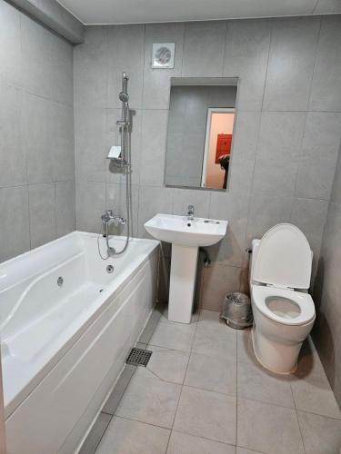 a bathroom with a tub and a toilet and a sink at Hotel Junoh in Seoul