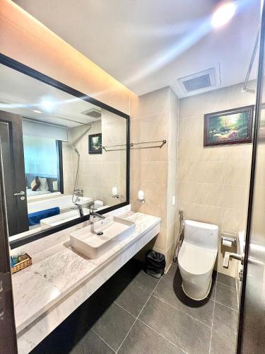 a bathroom with a sink and a toilet and a mirror at Sài Gòn Côn Đảo Resort in Con Dao