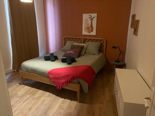 une chambre avec un lit avec une couverture rouge dessus dans l'établissement Appartement au centre d'Avignon, à Avignon