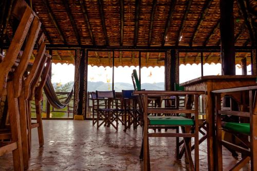 a room with wooden chairs and tables and windows at Casa Encuentro Ecolodge, Outdoor Gym and Yoga in Guatapé