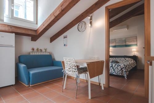 a living room with a table and a couch and a bed at PONTEROSSO TorreBianca Elegant Suite-Fibra WiFi in Trieste