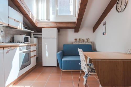 a kitchen with a table and a blue chair in a kitchen at PONTEROSSO TorreBianca Elegant Suite-Fibra WiFi in Trieste