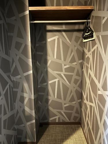 a wall mural with a geometric design in a bathroom at BEPPU HOSTEL U&T in Beppu