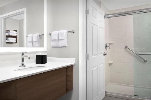 a white bathroom with a sink and a shower at Staybridge Suites North Charleston by IHG in Charleston
