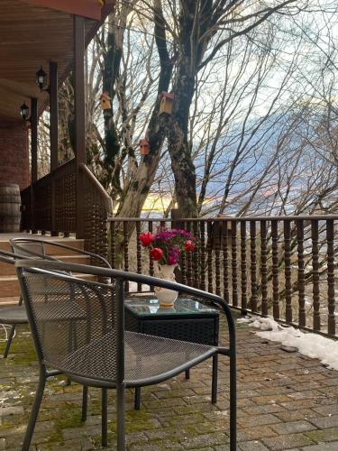 a chair and a table with a vase of flowers at Soisha in Jvari