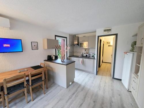 un salon avec une table et une cuisine dans l'établissement Le Jardin Provençal, au Lavandou