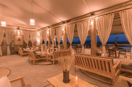 a restaurant with tables and chairs and curtains at MAISHA SWEETWATERS CAMP in Ol Pejeta Conservancy