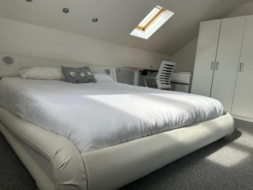 a large white bed in a room with at Seaside Home in Ardeer Square