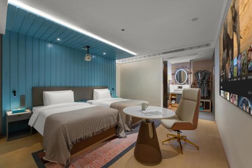 a hotel room with two beds and a table and a table at CityNote Hotel Guangzhou Yongqingfang Ximenkou Subway Station in Guangzhou