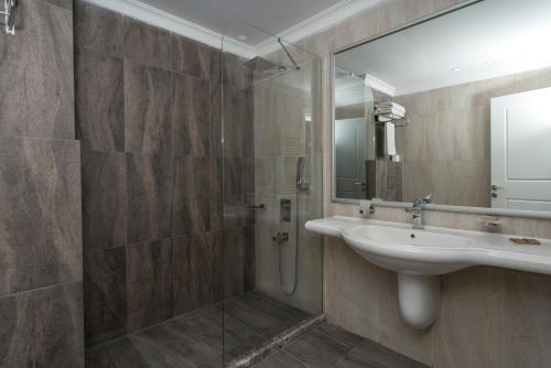 a bathroom with a sink and a shower at Bay Nihat Otel Lale in Ayvalık