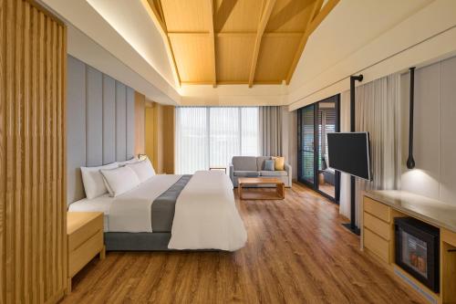 a hotel room with a bed and a tv at The Westin Yilan Resort in Yuanshan