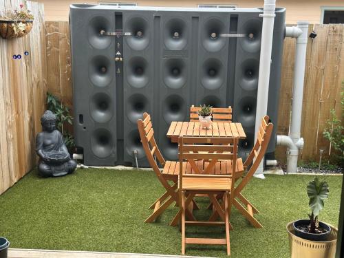 a wooden table and chairs on a lawn at AmritVilla21 in Auckland