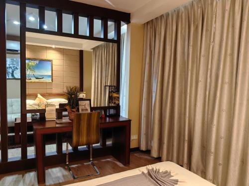 a bedroom with a desk and a bed and a mirror at Great Wall Hotel in Dar es Salaam