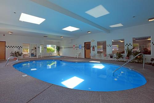 una grande piscina in una stanza con soffitto blu di Americas Best Value Inn & Suites-Forest Grove/Hillsboro a Forest Grove