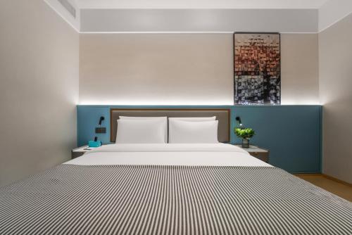 a bedroom with a large bed and a blue wall at CityNote Hotel Guangzhou Yongqingfang Ximenkou Subway Station in Guangzhou