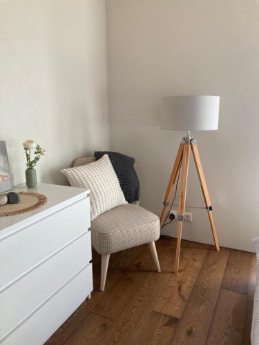 a room with a chair and a lamp and a dresser at Black House Spithami in Spithami