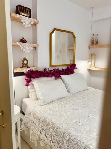 a bedroom with a white bed with purple flowers on it at Álas Holiday Home in Archangelos