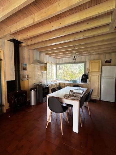 une cuisine avec une table et des chaises dans une pièce dans l'établissement Villa Pomme de Pin, à Quend-Plage