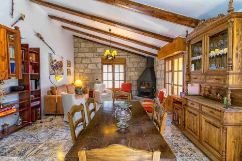 una sala da pranzo con tavolo e un soggiorno di Casa del Lago a Beceite