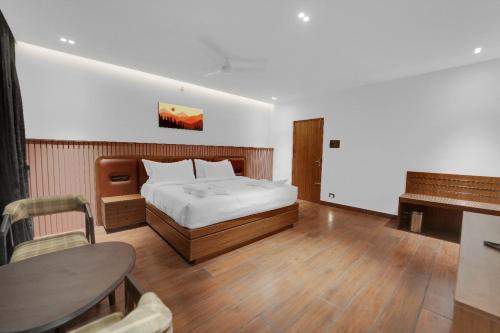 a bedroom with a bed and a table and a tableablish at The Forest Glen by TIO Hotels in Yercaud