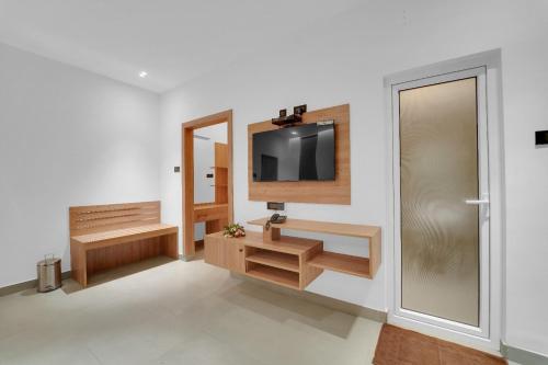 a living room with a tv on a wall at The Forest Glen by TIO Hotels in Yercaud