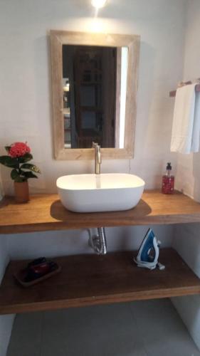 a bathroom with a white sink and a mirror at Apart Charme e Conforto 360m da Praia do Mutá in Coroa Vermelha