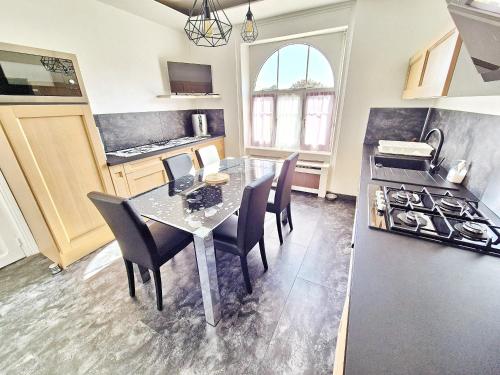 une cuisine avec une table, des chaises et une cuisinière dans l'établissement 731-Maison Bretonne a proximte des plages et des s, à Plouhinec