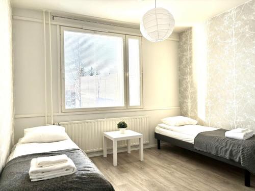 una camera da letto con due letti e una finestra di Cozy apartment in Kuusamo a Kuusamo