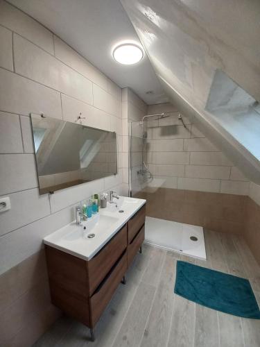 une salle de bain avec un lavabo, une baignoire et un miroir dans l'établissement Maison bord de mer, à Roscanvel
