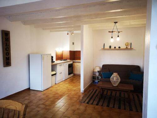 un salon avec un canapé et une cuisine dans l'établissement Charmant T2 avec grande terrasse et vue dégagée, à Sarrola-Carcopino