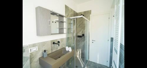 a bathroom with a sink and a shower at Rosa dei venti- Sea View Apartment - AC in Lido di Camaiore