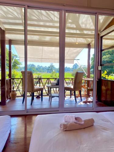 a room with a bed and a view of a patio at The Sun House อุทัยธานี in Ban Nam Tok