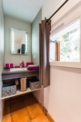 une salle de bain avec un lavabo et un miroir dans l'établissement La Villa De Port-Miou, à Cassis