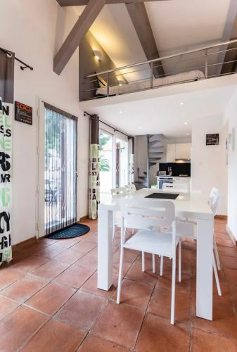 une salle à manger blanche avec une table et des chaises blanches dans l'établissement La Villa De Port-Miou, à Cassis