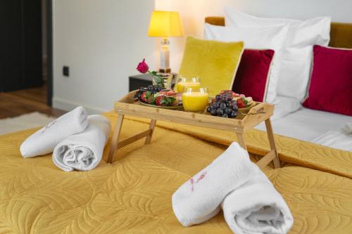 a table with towels and a tray of fruit on a bed at WILLA JAROSTA & SPA, AC -free parking in Zakopane