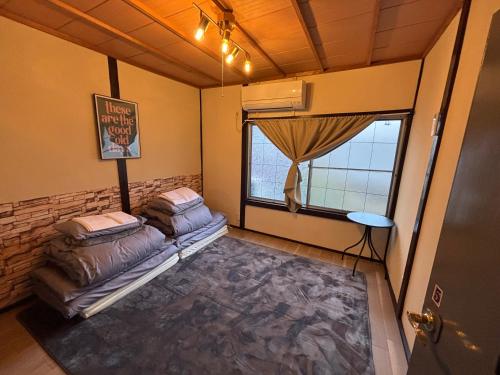 a room with a bed and a window at 777 Takamatsu Guest House in Takamatsu