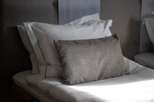 a white bed with a pillow on top of it at Michaelson Boutique Hotel & SPA Brícoła in Klaipėda