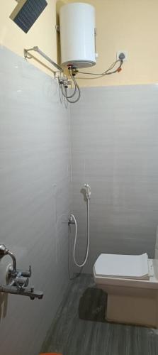a bathroom with a toilet and a light on the wall at VP Residency in Urapakkam