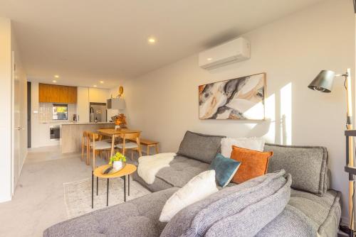 a living room with a couch and a table at Brand New Luxury 3 Bed 3 Baths Family Getaway in Christchurch