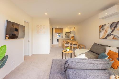 a living room with a couch and a table at Brand New Luxury 3 Bed 3 Baths Family Getaway in Christchurch