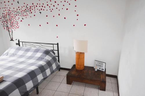 a bedroom with a bed and a table with a lamp at Casa Ginny in Orta San Giulio