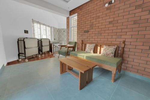 a room with a bench and a brick wall at The Forest Glen by TIO Hotels in Yercaud