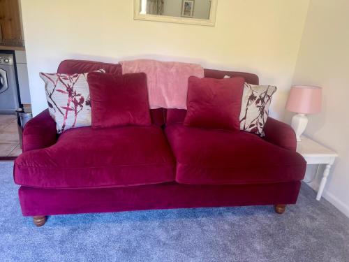 a purple couch with pillows on it in a living room at Self-contained Guest Suite, Michelmersh, Romsey in Michelmersh
