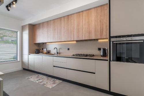 a kitchen with white counters and wooden cabinets at FozPenthouse in Foz do Arelho