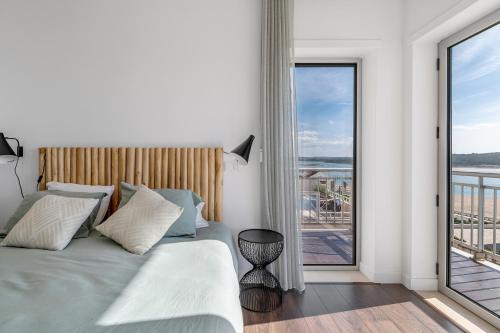 a bedroom with a bed and a large window at FozPenthouse in Foz do Arelho