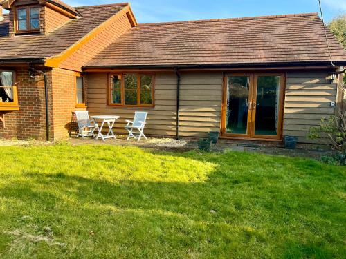 a house with a table and chairs in the yard at Self-contained Guest Suite, Michelmersh, Romsey in Michelmersh