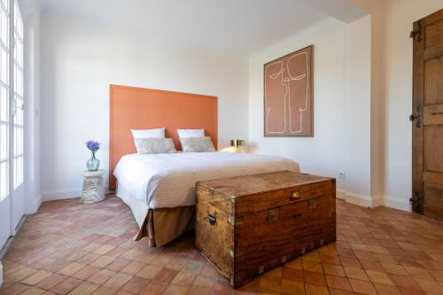 - une chambre avec un lit et un coffre en bois dans l'établissement MAISON BOURGEOISE COTE BLEU en centre ville, à Martigues